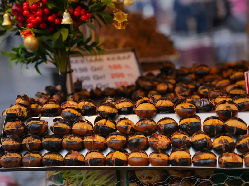 A display of roasted chestnuts at a vibrant street market in Bursa, Türkiye.