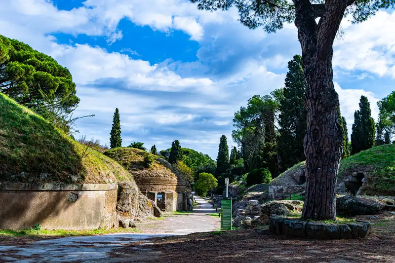 Explore the historic Etruscan Necropolis in Lazio, Italy, surrounded by lush greenery and ancient tombs.